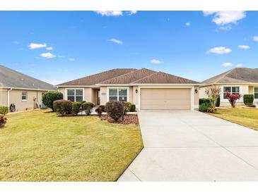 One-story home with attached garage, landscaped lawn, and driveway at 2954 Silk Tree Ter, The Villages, FL 32163