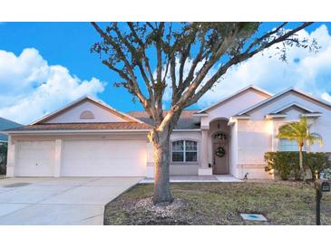 Single-story house with two-car garage and landscaped lawn at 335 Grand Reserve Dr, Davenport, FL 33837