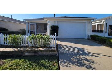 Charming single-story home featuring a well-manicured lawn and a classic white picket fence at 3621 Amelia Ave, The Villages, FL 32162