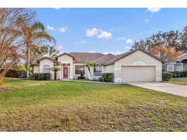 Single-story home with attached garage and well-maintained lawn at 36341 Grand Island Oaks Cir, Grand Island, FL 32735