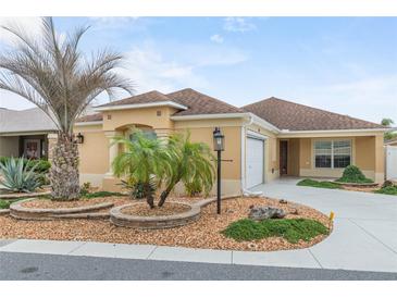 Single-story home with attractive landscaping and a two-car garage at 583 Arruda Ter, The Villages, FL 32162