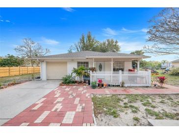 Charming home featuring a paved walkway, a well-manicured lawn, and a cozy front porch at 604 Palmetto Dr, Mascotte, FL 34753