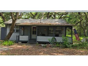 Quaint cottage-style home with a covered front porch, offering a relaxing outdoor space at 10094 Sw 153Rd Ln, Dunnellon, FL 34432