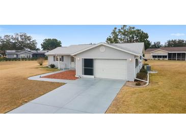 Single story home with attached garage and landscaped yard at 10476 Se 178Th St, Summerfield, FL 34491