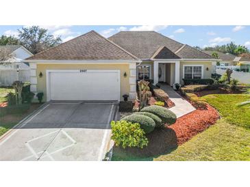 Single-story house with a two-car garage and well-manicured lawn at 2587 Tremont Dr, Eustis, FL 32726