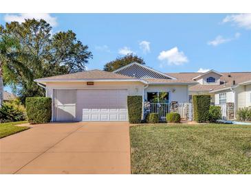 Cute and cozy one-story home with attached garage and well-manicured landscaping at 26607 Racquet Cir, Leesburg, FL 34748