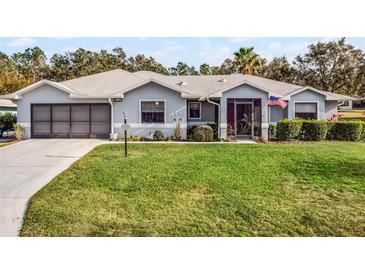 One-story home with gray exterior, screened porch, and landscaped lawn at 27039 Racquet Cir, Leesburg, FL 34748