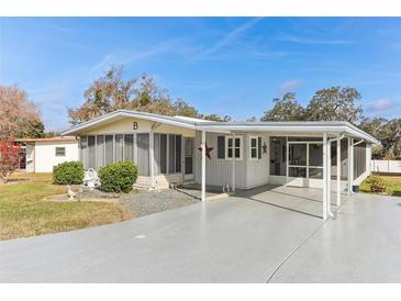 Inviting single-story home featuring a spacious carport and well-manicured front lawn at 11 Orangewood Dr, Fruitland Park, FL 34731