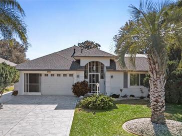 Single-story home with gray roof, white walls, and a landscaped yard at 21152 Royal St Georges Ln, Leesburg, FL 34748