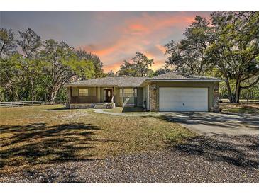 Charming single story home featuring stone accents, a two-car garage, and a lovely front porch at 3380 Cr 528, Sumterville, FL 33585