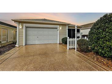 House exterior featuring a garage and a well-maintained front yard at 3764 Ivey Ter, The Villages, FL 32163