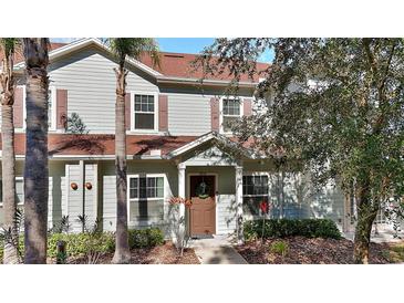 Two-story townhome with light gray siding, brown roof, and landscaping at 8988 Silver Pl, Kissimmee, FL 34747