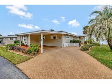 Charming single story home with a covered carport and a long driveway, plus mature tropical landscaping at 13 Sunrise Trl, Fruitland Park, FL 34731
