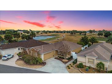 Aerial view of a beautiful home on a golf course with a stunning sunset at 1941 Loadstar Ave, The Villages, FL 32162