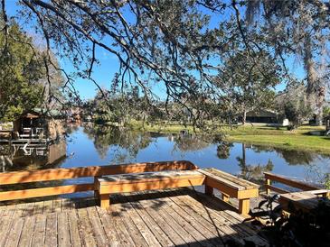 Relaxing waterfront deck with wooden benches overlooking a peaceful lake at 208 First St, Tavares, FL 32778