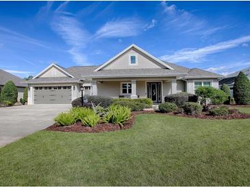 One-story home with gray siding, landscaping, and a two-car garage at 3735 Conservation Trl, The Villages, FL 32163