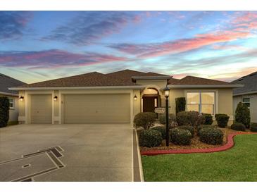 Two-car garage, landscaped yard, and charming curb appeal at 4348 Tuscaloosa Path, The Villages, FL 32163