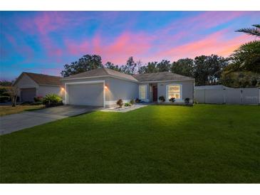 House exterior at dusk showcasing a well-maintained lawn and garage at 460 Brook Ridge Cir, Minneola, FL 34715