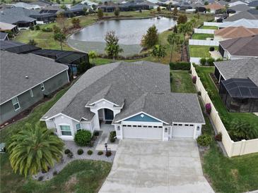 Single-Gathering home with three-car garage, lake view, and landscaped yard at 5078 Lawler Loop, The Villages, FL 32163