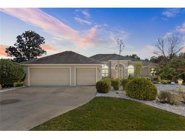 Beautiful two-story home with a three-car garage and well-manicured lawn at 6026 Landings Blvd, Lady Lake, FL 32159