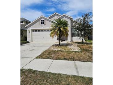 Charming single-Gathering home featuring a two-car garage and a well-maintained front yard with a palm tree at 1745 Caribou Hunt Trl, Orlando, FL 32824