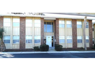 Brick condo building with multiple units and landscaping at 723 Perkins St # 104, Leesburg, FL 34748