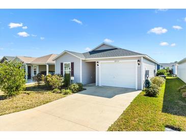 Charming single-story home with a well-maintained lawn and a concrete driveway leading to an attached garage at 3822 Miragalia Ln, The Villages, FL 32163