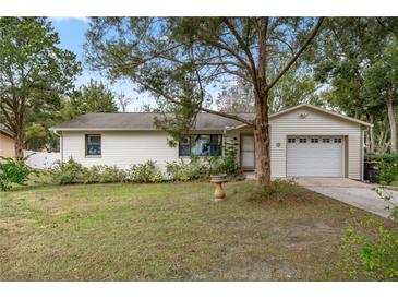 House exterior featuring a ranch-style home with a single garage and well-maintained lawn at 5301 Se 115Th Pl, Belleview, FL 34420