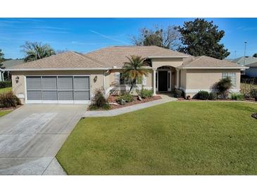 Single-story home with attached garage and well-manicured lawn at 8460 Se 137Th Loop, Summerfield, FL 34491