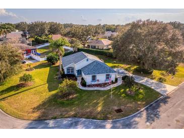 Beautiful, landscaped single Gathering home featuring lush lawn, mature trees and driveway in a quiet neighborhood at 85 Golfview Cir, Umatilla, FL 32784