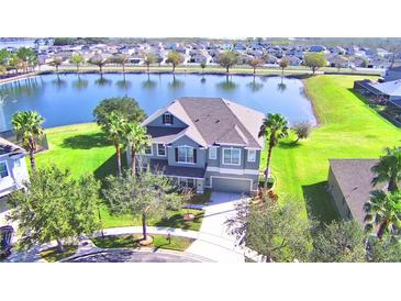 Two-story house with lake view, lush landscaping, and spacious yard at 113 Pecorri Ct, Auburndale, FL 33823