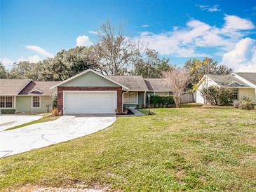 Charming one-story home with a well-maintained lawn and a two-car garage at 11744 Oswalt Rd, Clermont, FL 34711