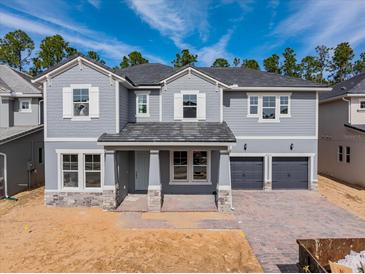 Two-story home with gray siding and a three-car garage at 14261 Crest Palm Ave, Windermere, FL 34786