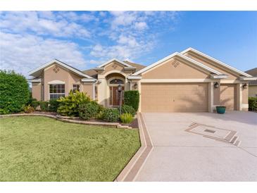 Beautiful single-story home with manicured lawn, mature landscaping, and a spacious three-car garage at 2017 Royal Elm Rd, The Villages, FL 32162