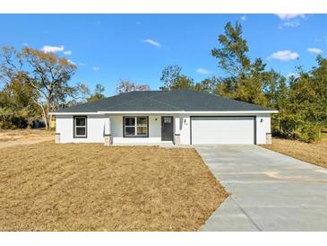 Newly constructed home with white exterior, gray roof, and two-car garage at 202 Shannon Ln, Lady Lake, FL 32159