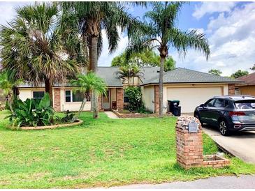 One-story house with brick facade, attached garage, and lush landscaping at 20733 Melville St, Orlando, FL 32833