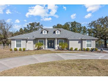 Charming single-story home features a circular drive and well-maintained landscaping at 24429 Adair Ave, Sorrento, FL 32776