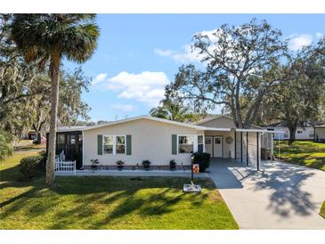 Single-story home with carport and landscaped lawn at 25547 Belle Helene, Leesburg, FL 34748