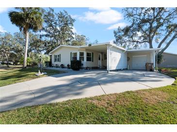 Mobile home with carport and landscaped yard at 25547 Belle Helene, Leesburg, FL 34748