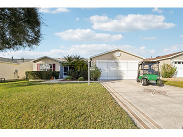 Inviting single-story home features a well-manicured lawn, mature landscaping, and a two-car garage at 3319 Thorncrest Dr, The Villages, FL 32162