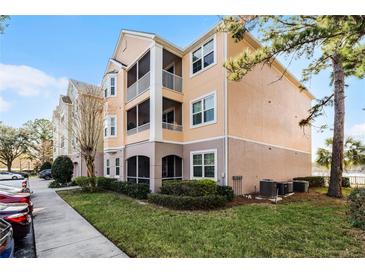 Attractive condo exterior with balconies, lush lawn and green shrubs in a well-maintained community at 3480 Soho St # 206, Orlando, FL 32835