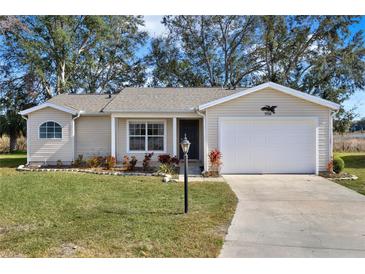 Charming single-story home featuring a manicured lawn, attached garage, and inviting front entrance at 5338 Tigers Tail, Leesburg, FL 34748