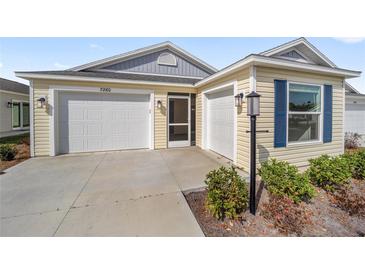 Charming home with two-car garage, well-manicured landscaping, and screened front porch entry at 7260 Draper Ave, The Villages, FL 34762