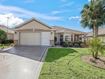 Charming single-story home with a well-manicured lawn, attractive landscaping, and a two-car garage at 8662 Se 133Rd Ln, Summerfield, FL 34491