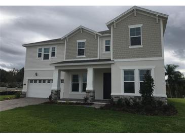 Charming two-story home featuring stone accents and a well-manicured lawn at 14365 Crest Palm Ave, Windermere, FL 34786