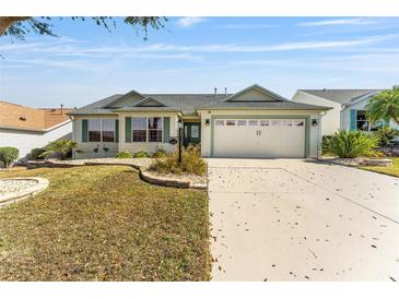 Charming single-story home featuring a well-manicured front yard and attached two-car garage at 1555 Ward Ct, The Villages, FL 32162