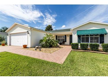 Charming single story home with beautiful landscaping, brick walkway and two car garage at 3218 Woodridge Dr, The Villages, FL 32162