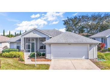 Charming single-story home with a screened porch, two-car garage, and well-manicured landscaping at 5095 China Sea Dr, Tavares, FL 32778