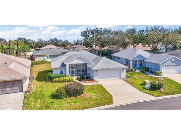 Charming single-story home with attached garage, screened porch, and well-manicured lawn in a friendly neighborhood at 5095 China Sea Dr, Tavares, FL 32778