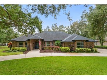 Brick home with landscaped yard and driveway at 5910 Lake Emma Ct, Groveland, FL 34736